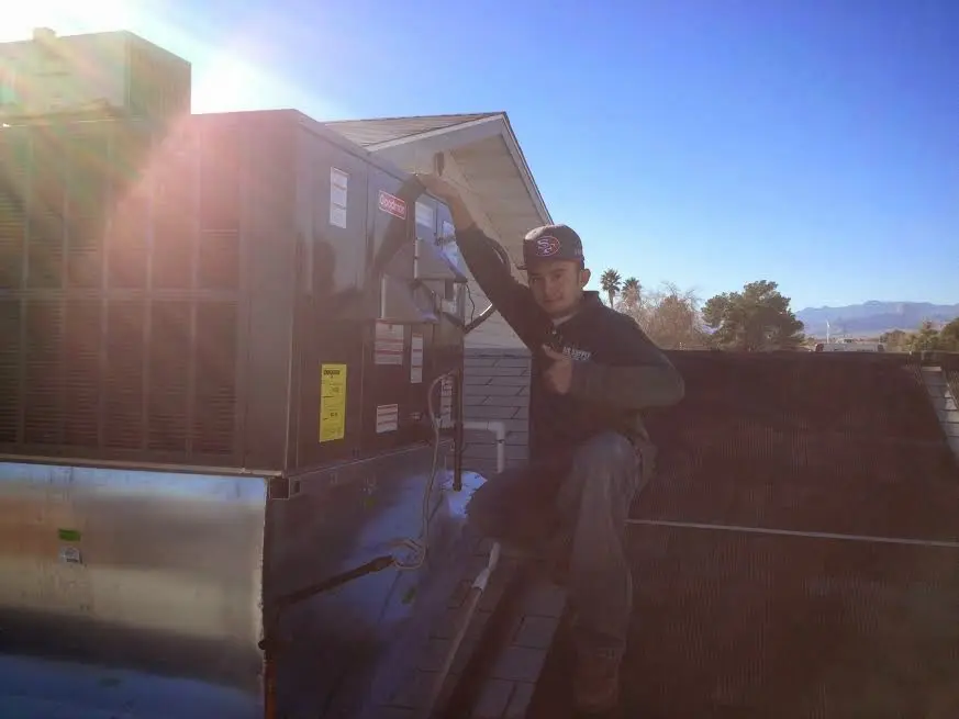 HVAC technician performing Heat Pump Repair on a rooftop unit in Belle Fourche